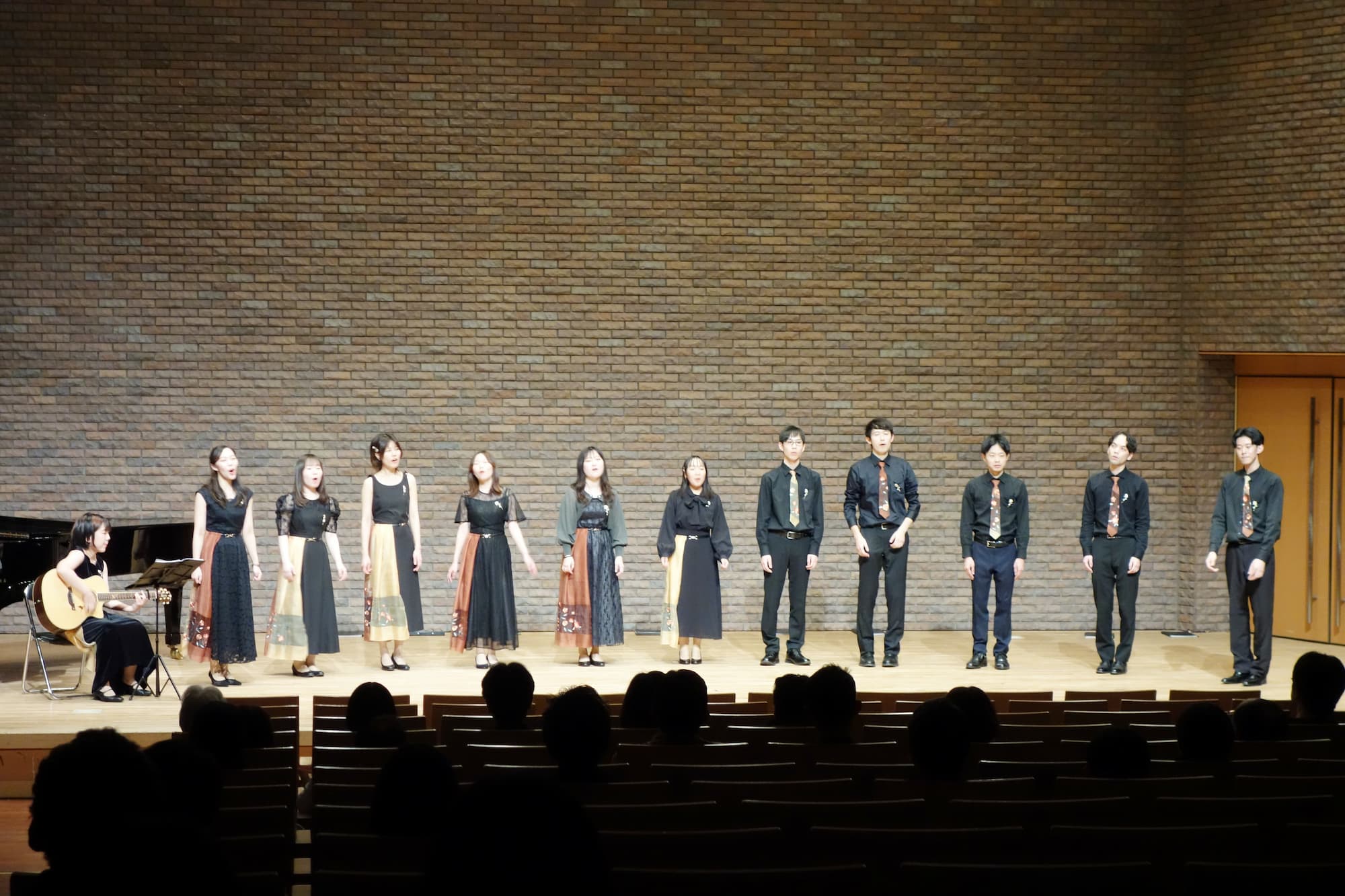 11名でお揃いの衣装で歌う様子